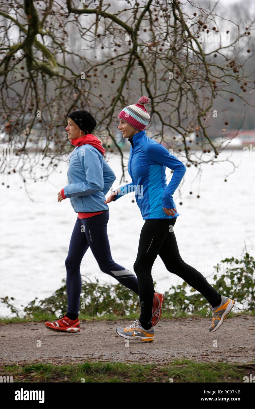 Deux jeunes femmes jogging en hiver, portant des vêtements de performance imperméable et coupe-vent Banque D'Images