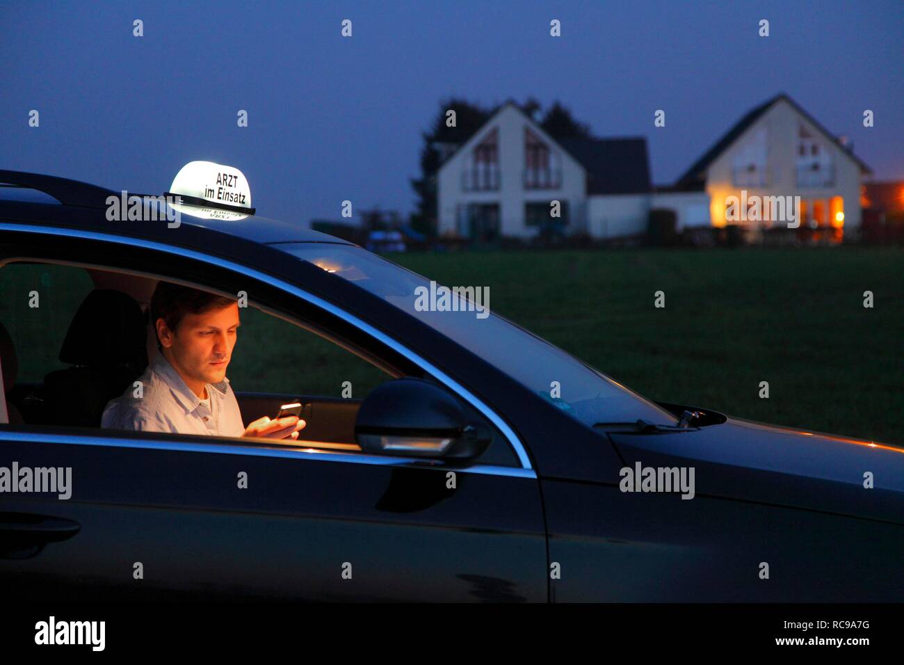 Jeune médecin, omnipraticien travaillant dans le pays, faisant appel à sa voiture après une soirée visite à domicile, car l'affichage Banque D'Images Jeune médecin, omnipraticien travaillant dans le pays, faisant appel à sa voiture après une soirée visite à domicile, car l'affichage Banque D'Images