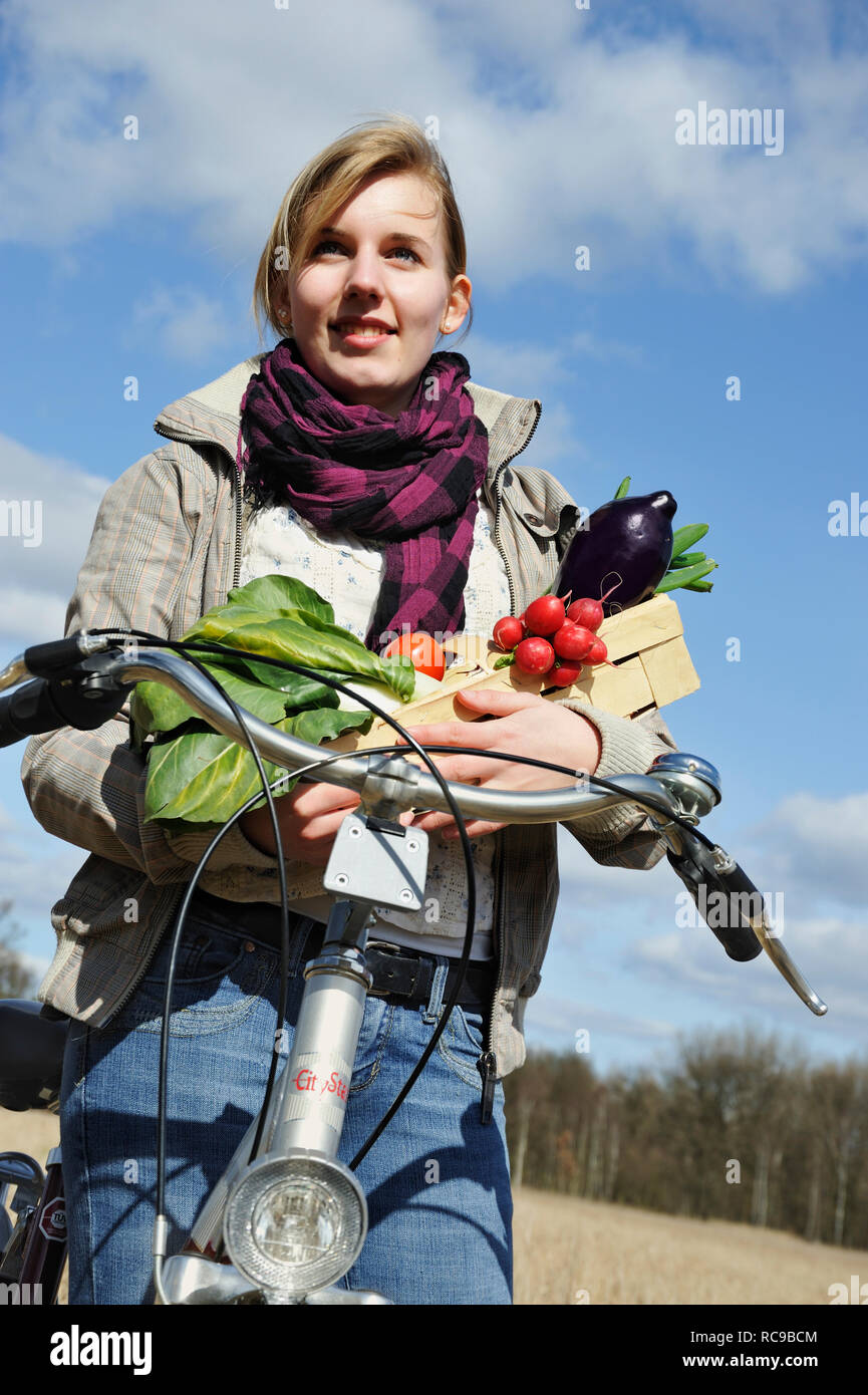 Junge Frau mit Fahhrad Gemüsekorb - junges Gemüse und | Les jeunes femmes avec son vélo et panier de légumes Banque D'Images