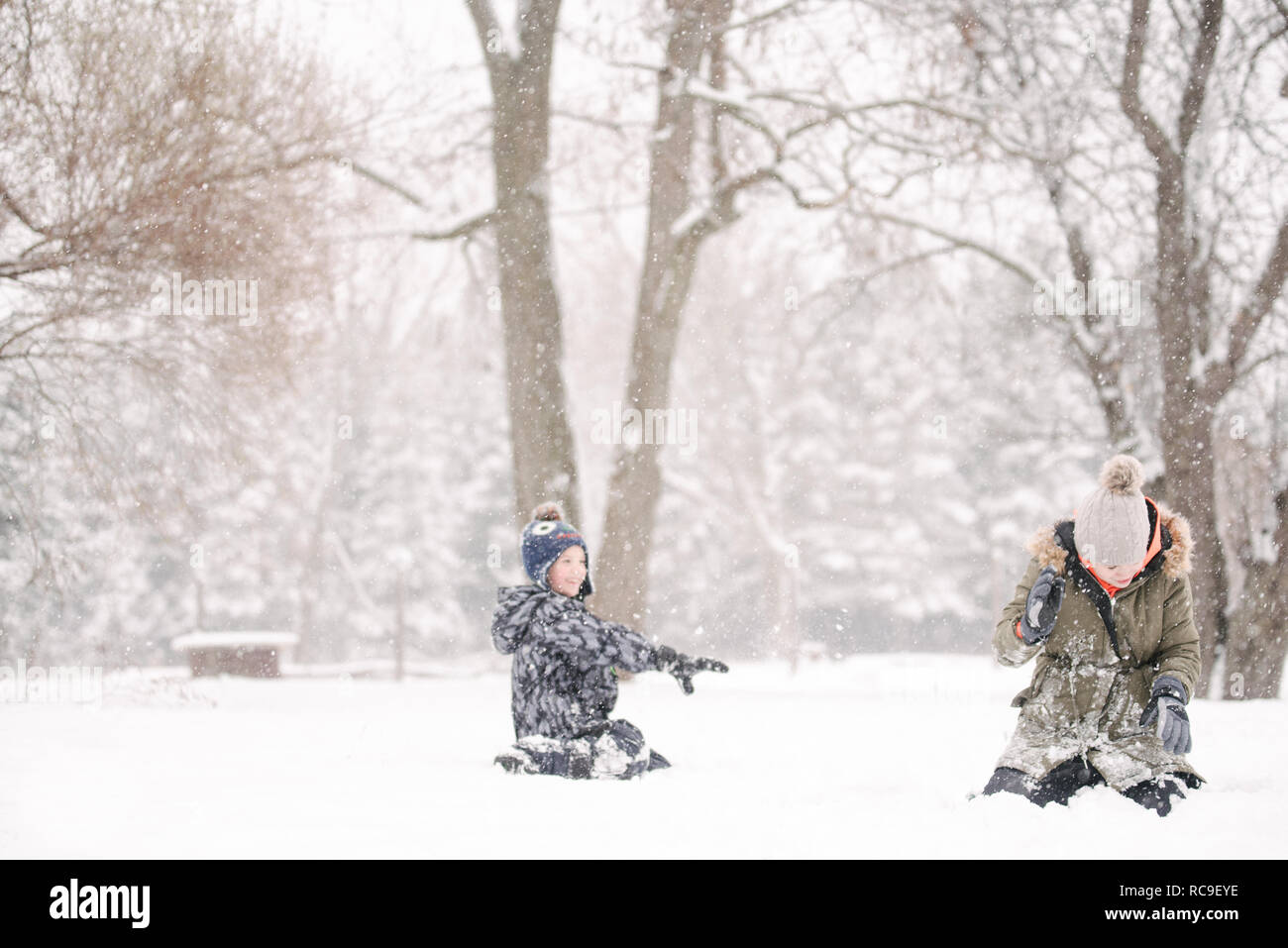 Boy throwing snowball à sœur Banque D'Images