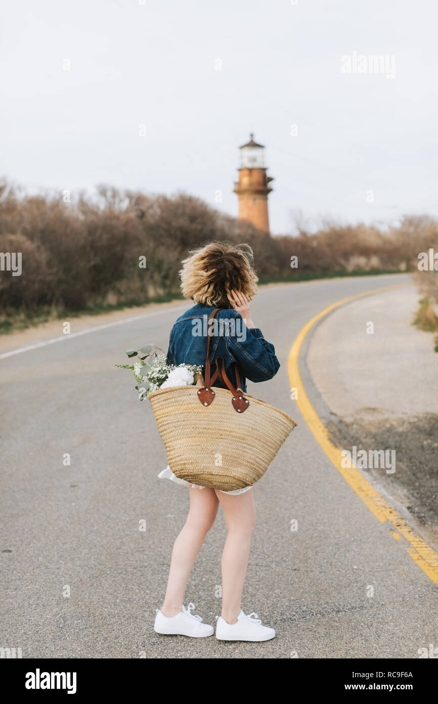 Jeune femme on rural road à au lighthouse, vue arrière, Menemsha, Martha's Vineyard, Massachusetts, USA Banque D'Images