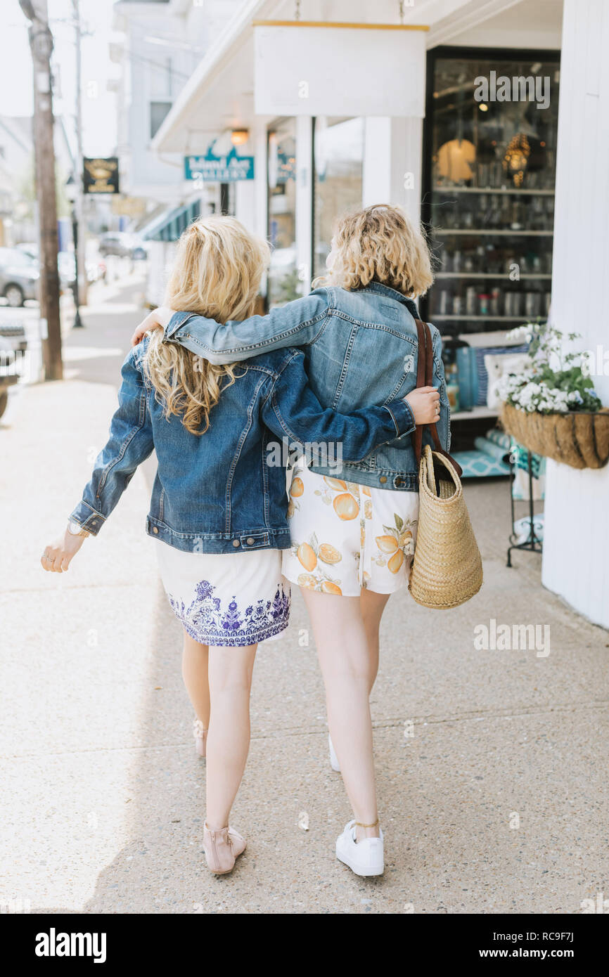 Deux jeunes amies se promener le long des trottoirs du village, vue arrière, Menemsha, Martha's Vineyard, Massachusetts, USA Banque D'Images