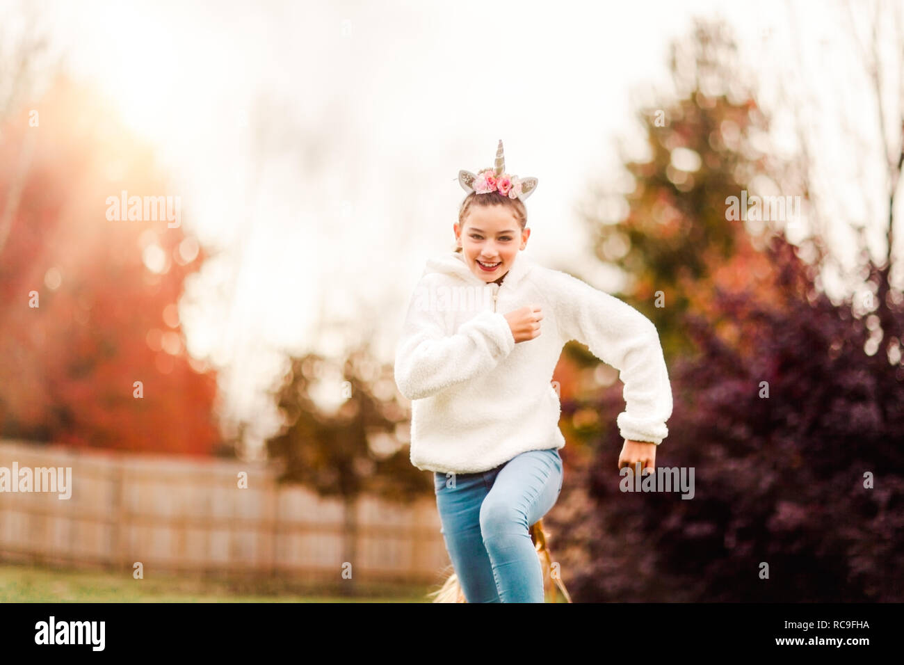 Girl avec unicorn bandeau running in park Banque D'Images