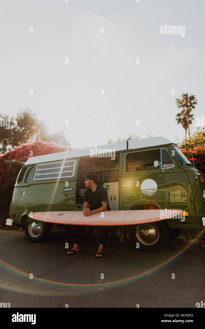 L'homme sur van voyage avec sa planche de surf, Ventura, Californie, États-Unis Banque D'Images