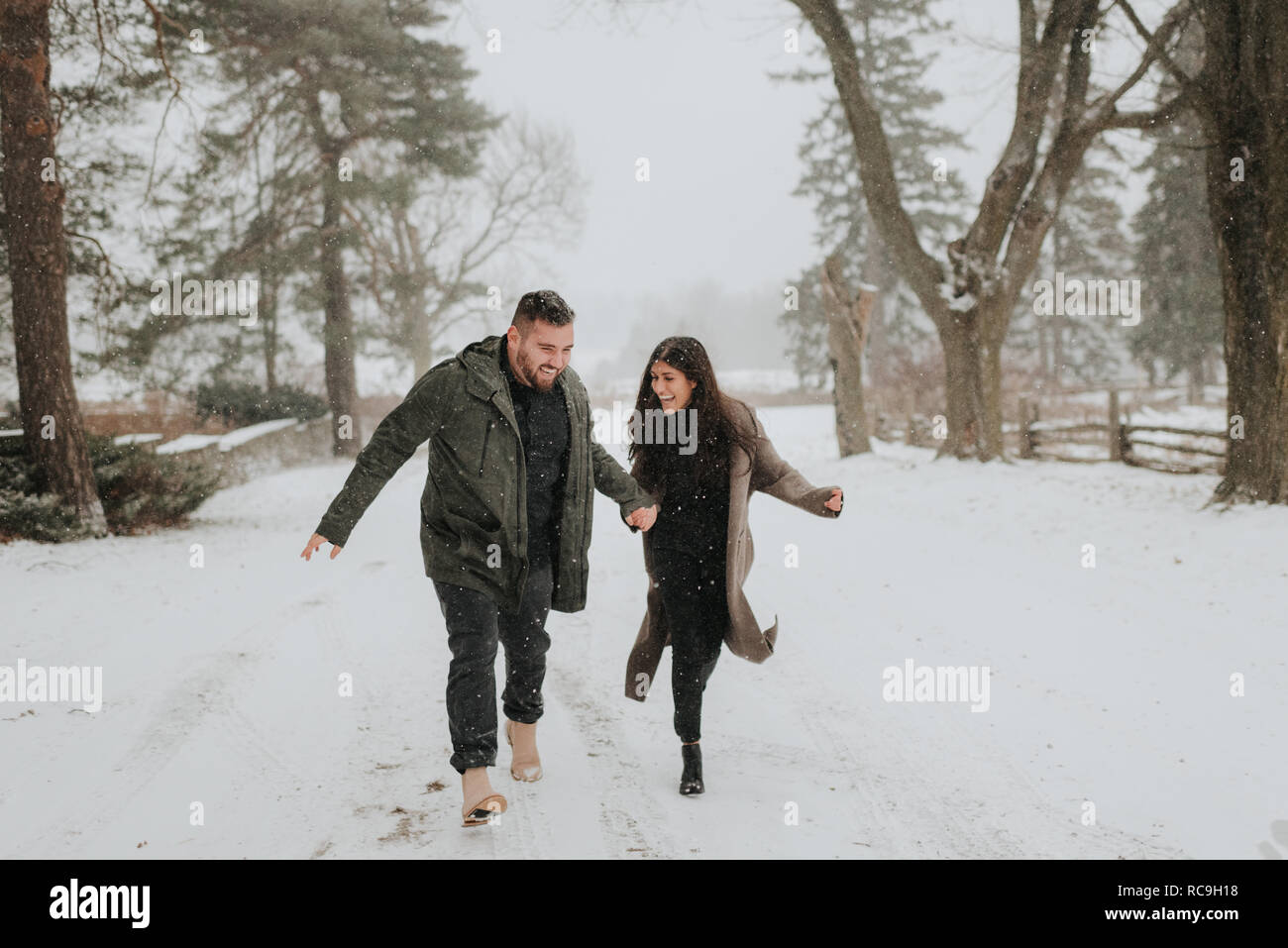 Couple running in snowy landscape, Georgetown, Canada Banque D'Images
