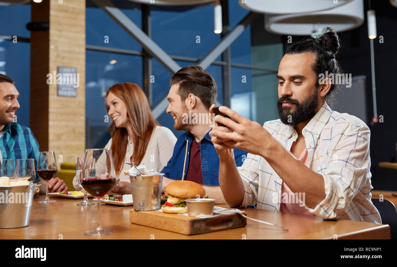 L'homme de la messagerie instantanée sur smartphone en restaurant Banque D'Images