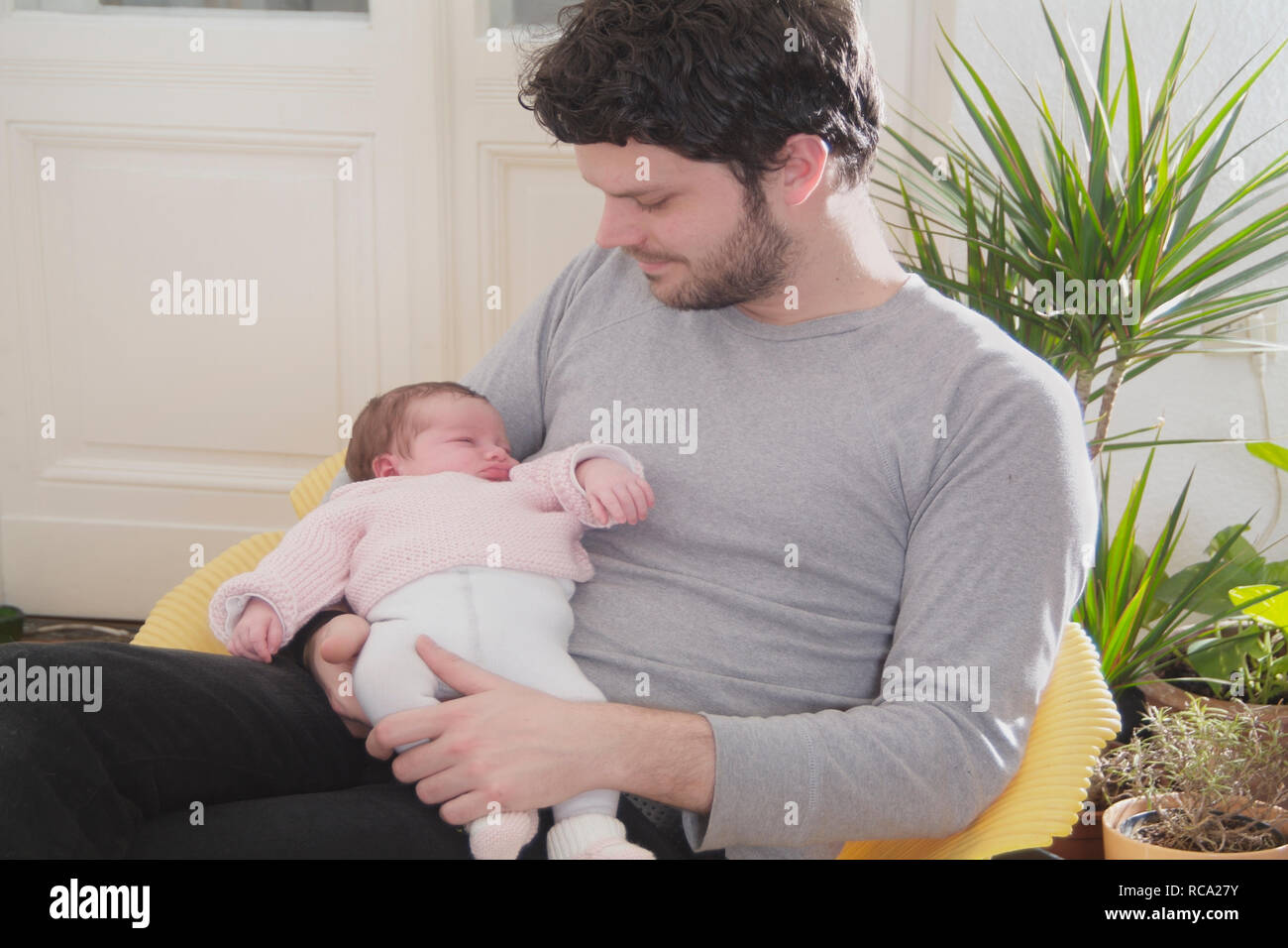 Neugeborene Junger hält seine Tochter im Arm, das ist genre 12 Tage alt | jeune père tenant son bébé nouveau-né dans ses bras - le bébé âgé de 12 jours ist Banque D'Images