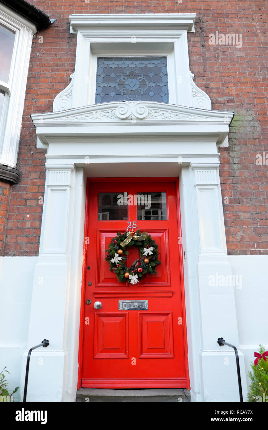 Couronne de Noël avec des boules et de background sur l'extérieur d'une porte rouge à Shrewsbury Shropshire England UK KATHY DEWITT Banque D'Images