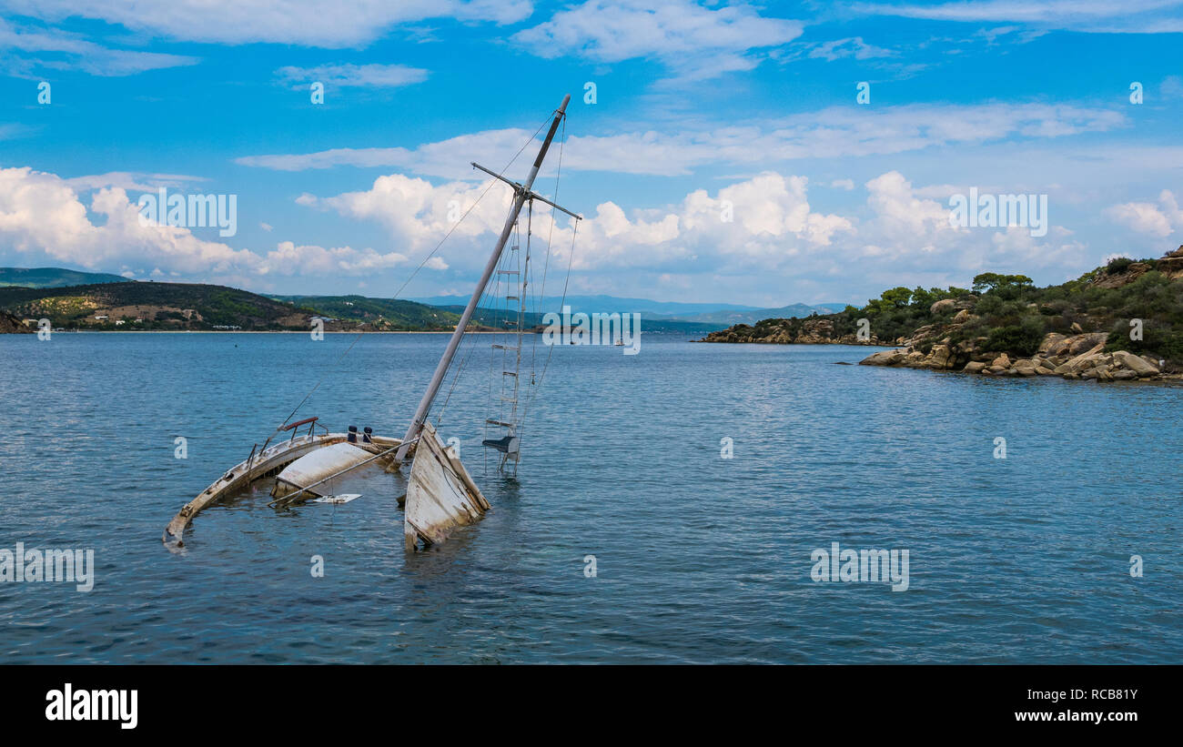 Des naufragés yacht à demi submergé dans une eau calme baie à un endroit exotique magnifique en Grèce Banque D'Images