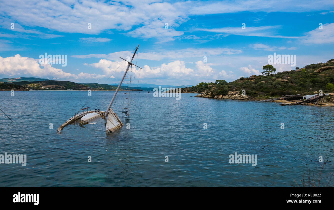 Des naufragés yacht à demi submergé dans une eau calme baie à un endroit exotique magnifique en Grèce Banque D'Images