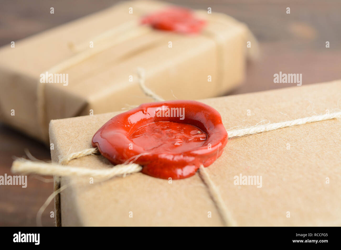 Cadeaux dans du papier craft avec de la cire sur la table en bois brun Banque D'Images
