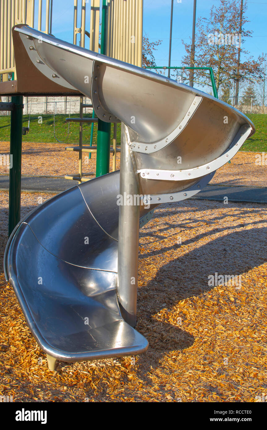 Un metal spiral slide partie de certains appareils de jeux d'une aire de jeux dans un parc local à Pitt Meadows, Colombie-Britannique, Canada. Banque D'Images