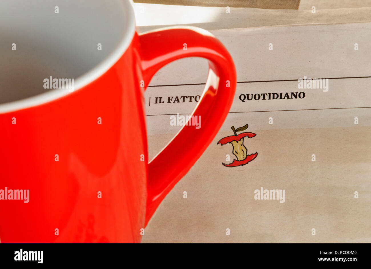 Le journal Il Fatto Quotidiano sur une table , au premier plan dans le cadre d'un mug rouge Banque D'Images