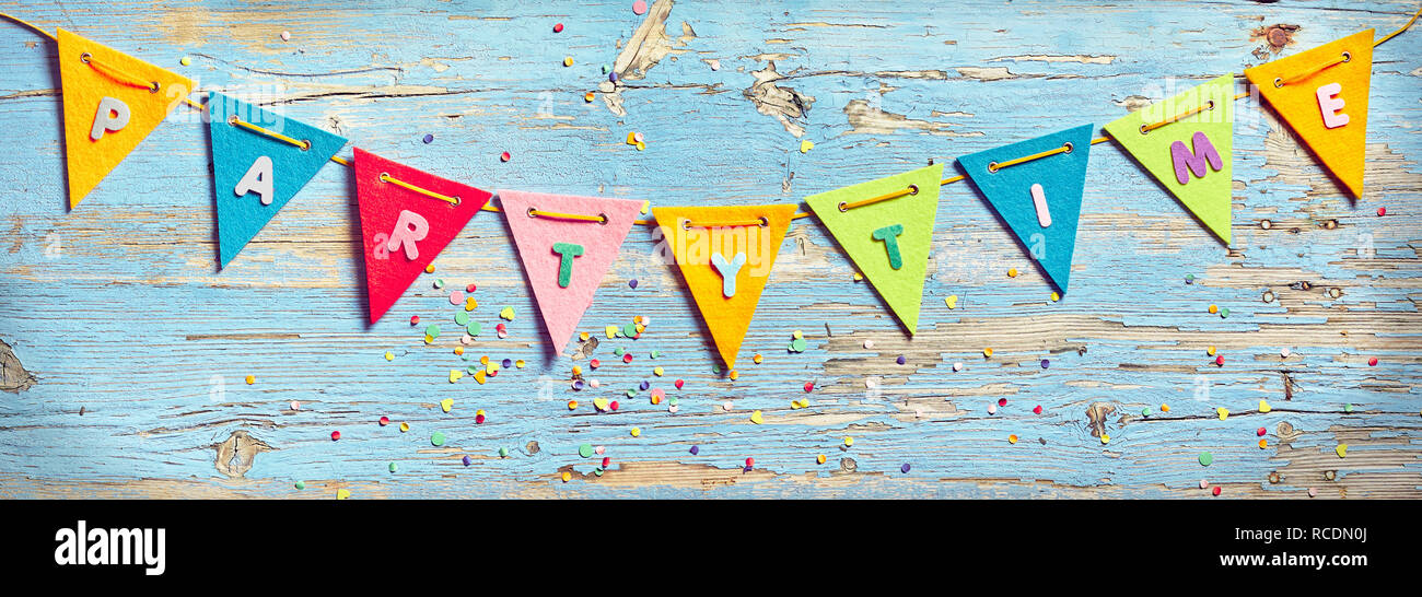 Party Time noir sur fond de bois de vieille peinture bleu, décoré de confettis colorés. Arrière-plan de célébration Banque D'Images