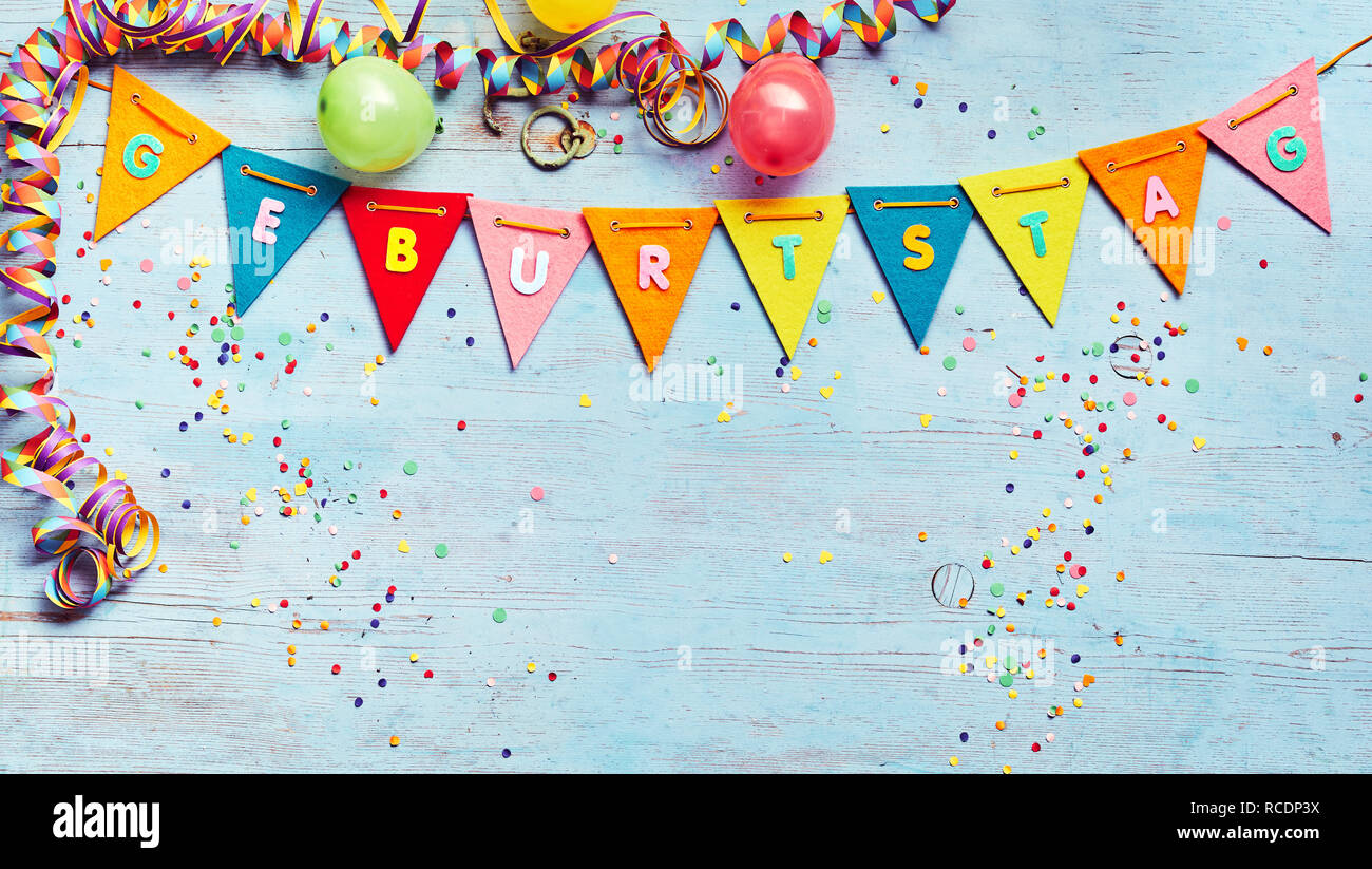 Geburtstag ou fête d'arrière-plan avec des banderoles et des ballons au-dessus d'une chaîne de texte coloré bunting avec l'allemand et l'espace ci-dessous copie sur bleu w Banque D'Images