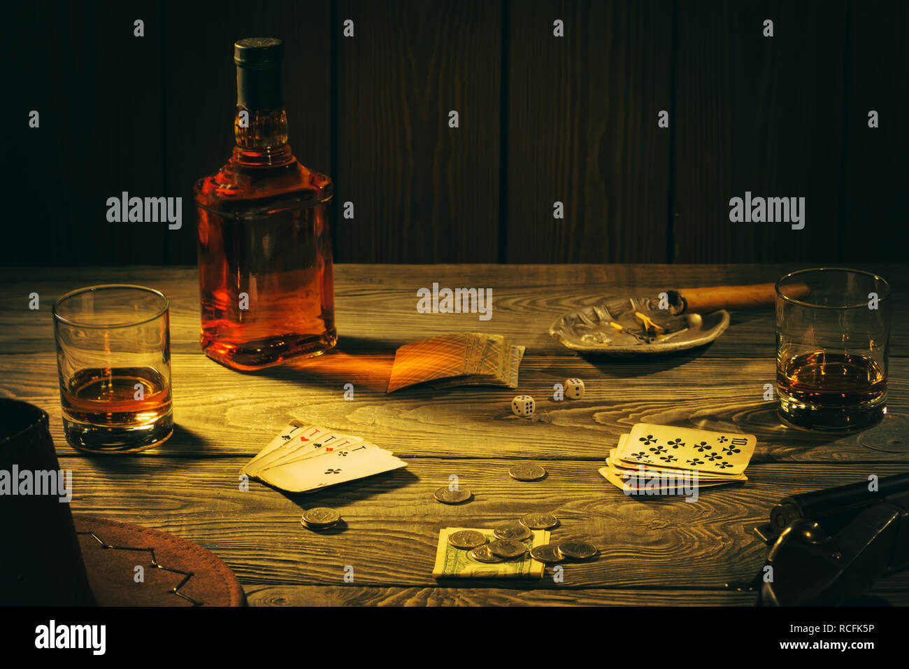 Table avec des cartes à jouer, de whisky, de cigare et d'armes Banque D'Images