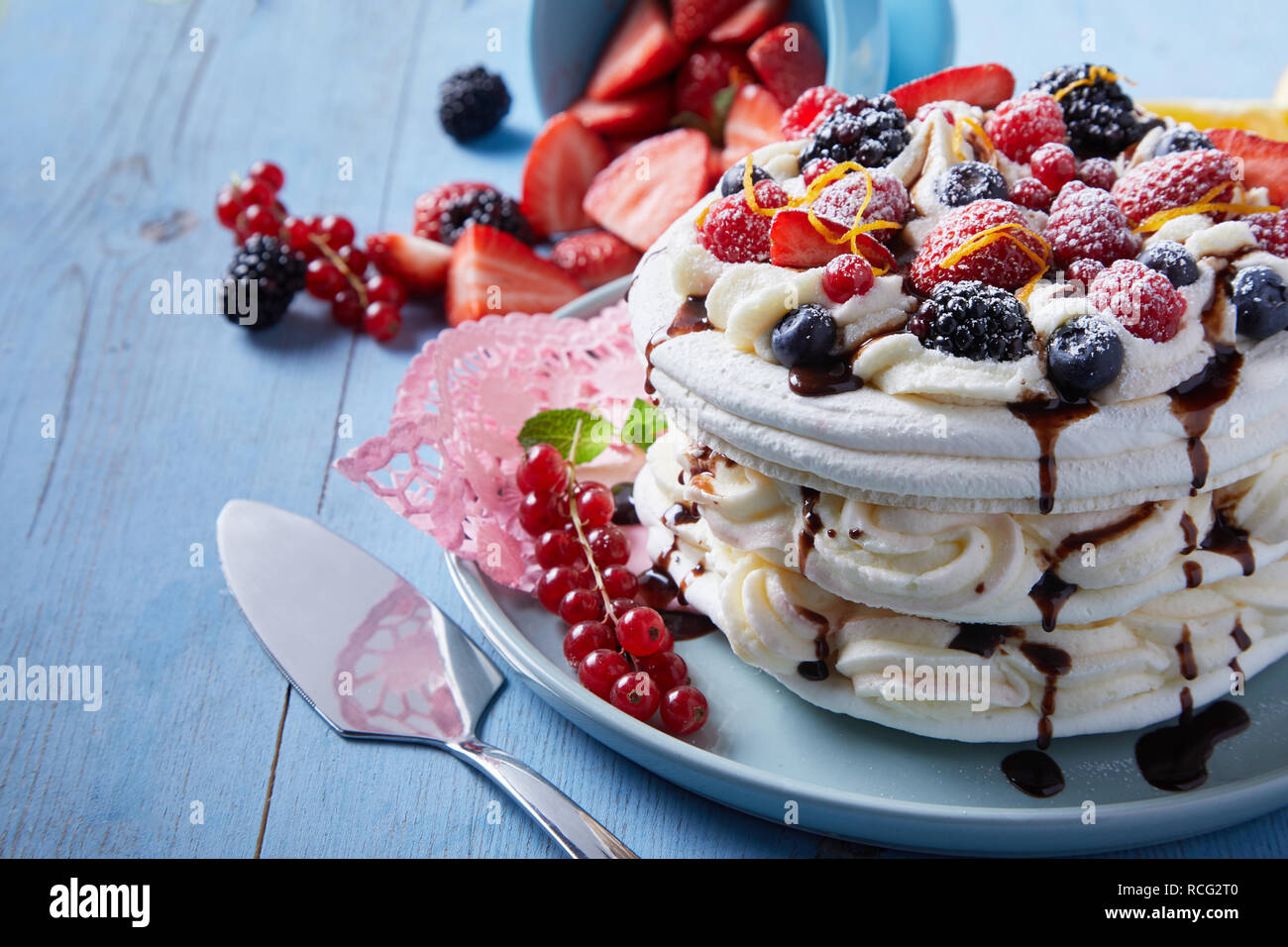 Recette Gourmande Pour Pavlova Meringuee Dessert Avec Des Couches De Creme Fouettee Surmontee D Une Variete De Fruits Frais Et De Zeste D Orange Arrosees De Chocolat Photo Stock Alamy