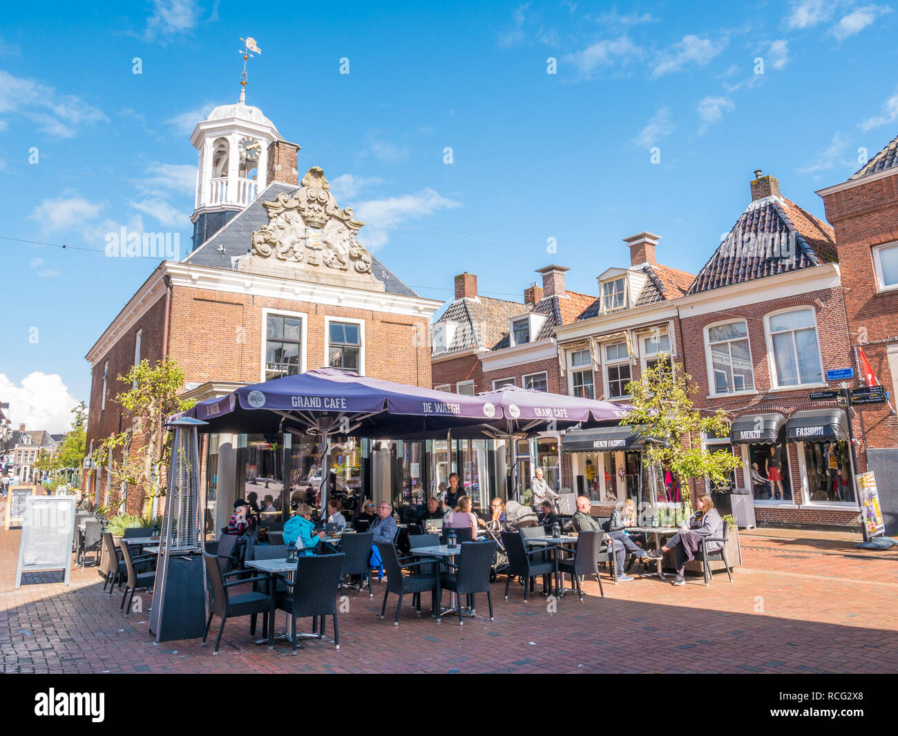Les gens se détendre sur une terrasse extérieure de grand cafe dans la ville historique de balance dans la vieille ville de Dokkum, Frise, Pays-Bas Banque D'Images