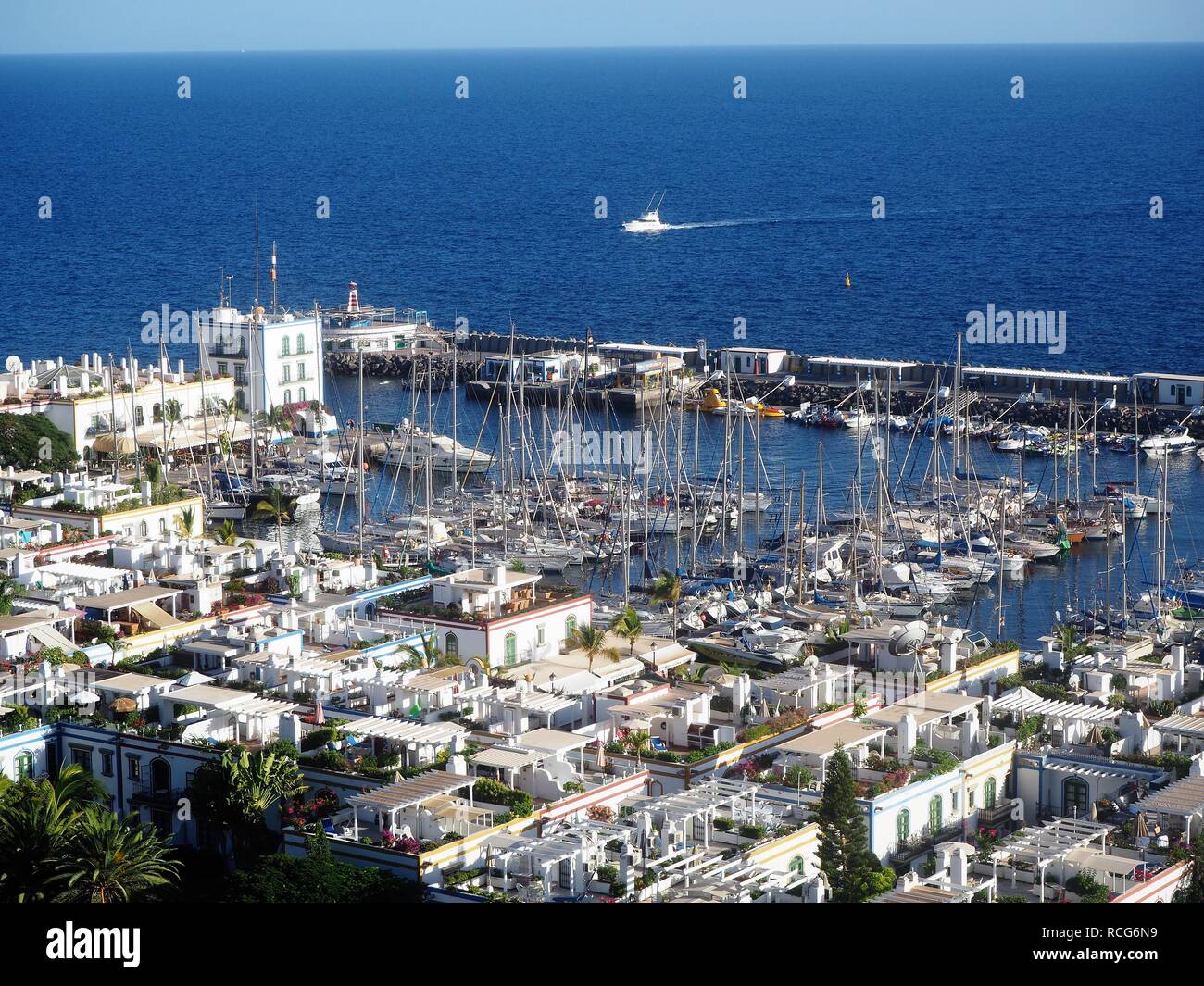 Vue sur le port pittoresque de Puerto de Mogan, Gran Canaria dans les îles Canaries, avec des bateaux à voile et un océan et le ciel bleu Banque D'Images