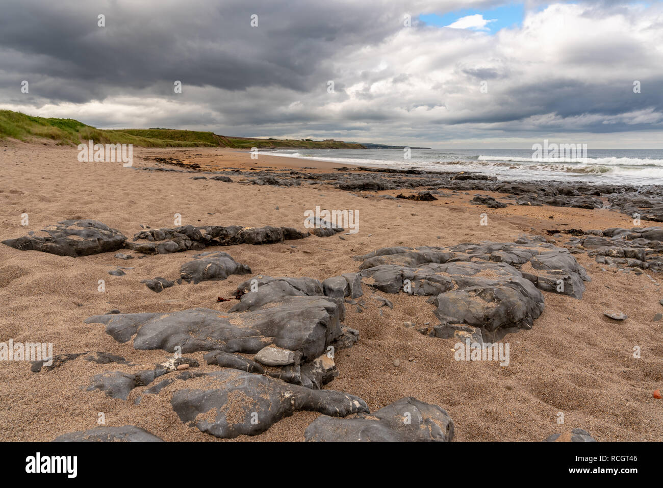 Nuages sombres et les grosses pierres, vu à Cocklawburn Beach près de Berwick-upon-Tweed dans le Northumberland, England, UK Banque D'Images