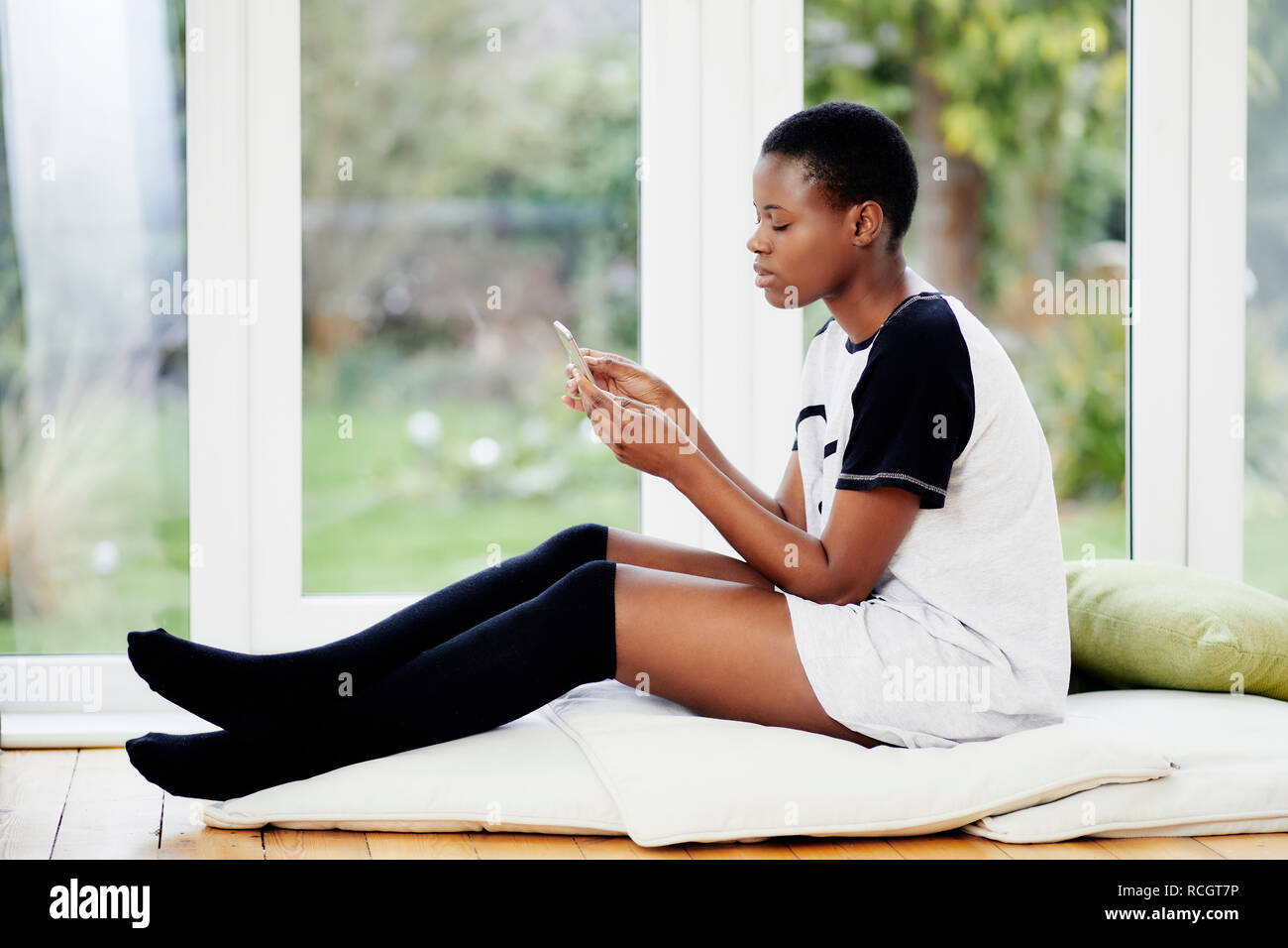 Fille ethnique à la détente à son téléphone Banque D'Images