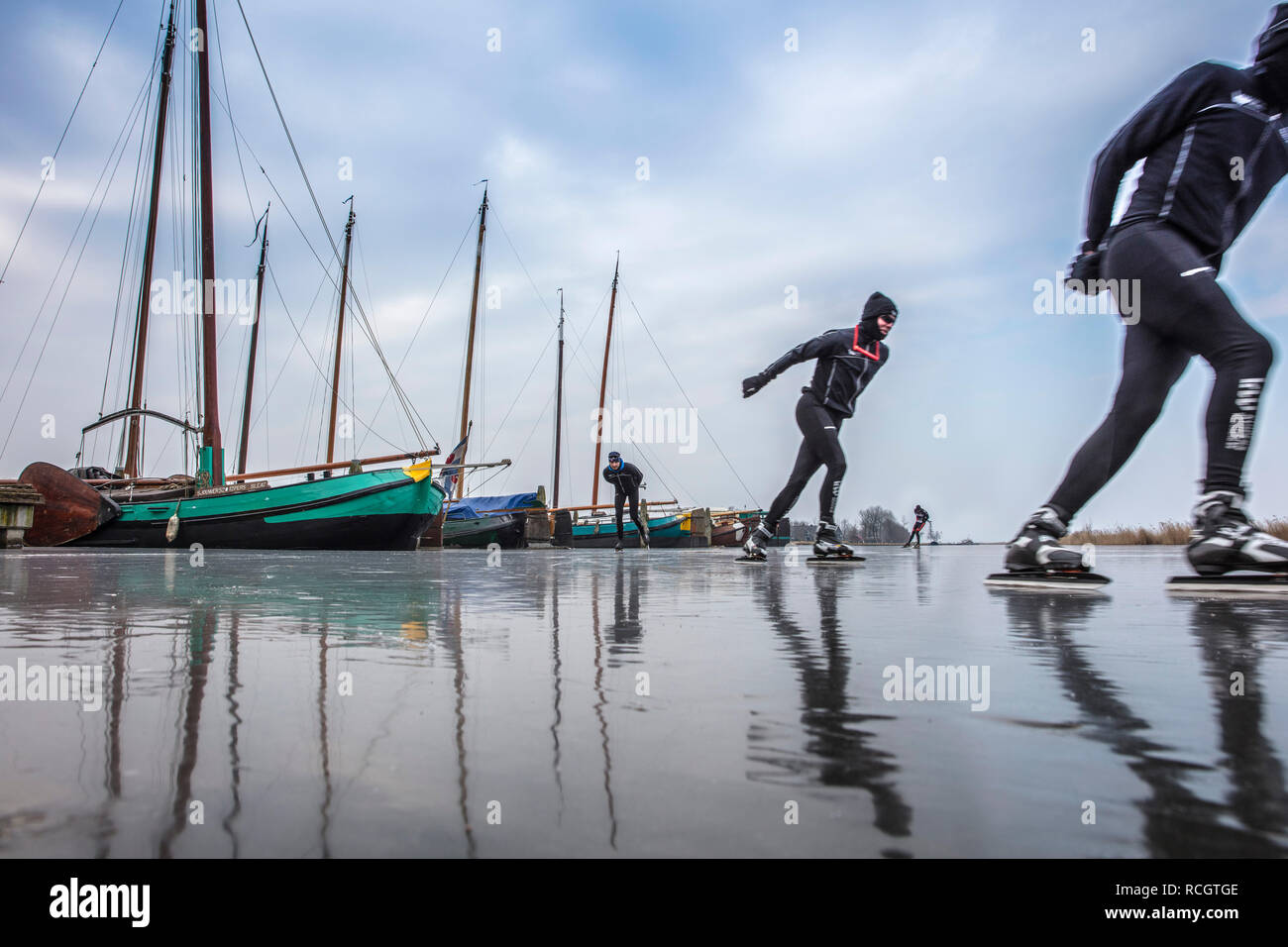 Les Pays-Bas, Sloten, patinage sur glace. Contexte du fret traditionnel des bateaux à voile. L'hiver. Banque D'Images