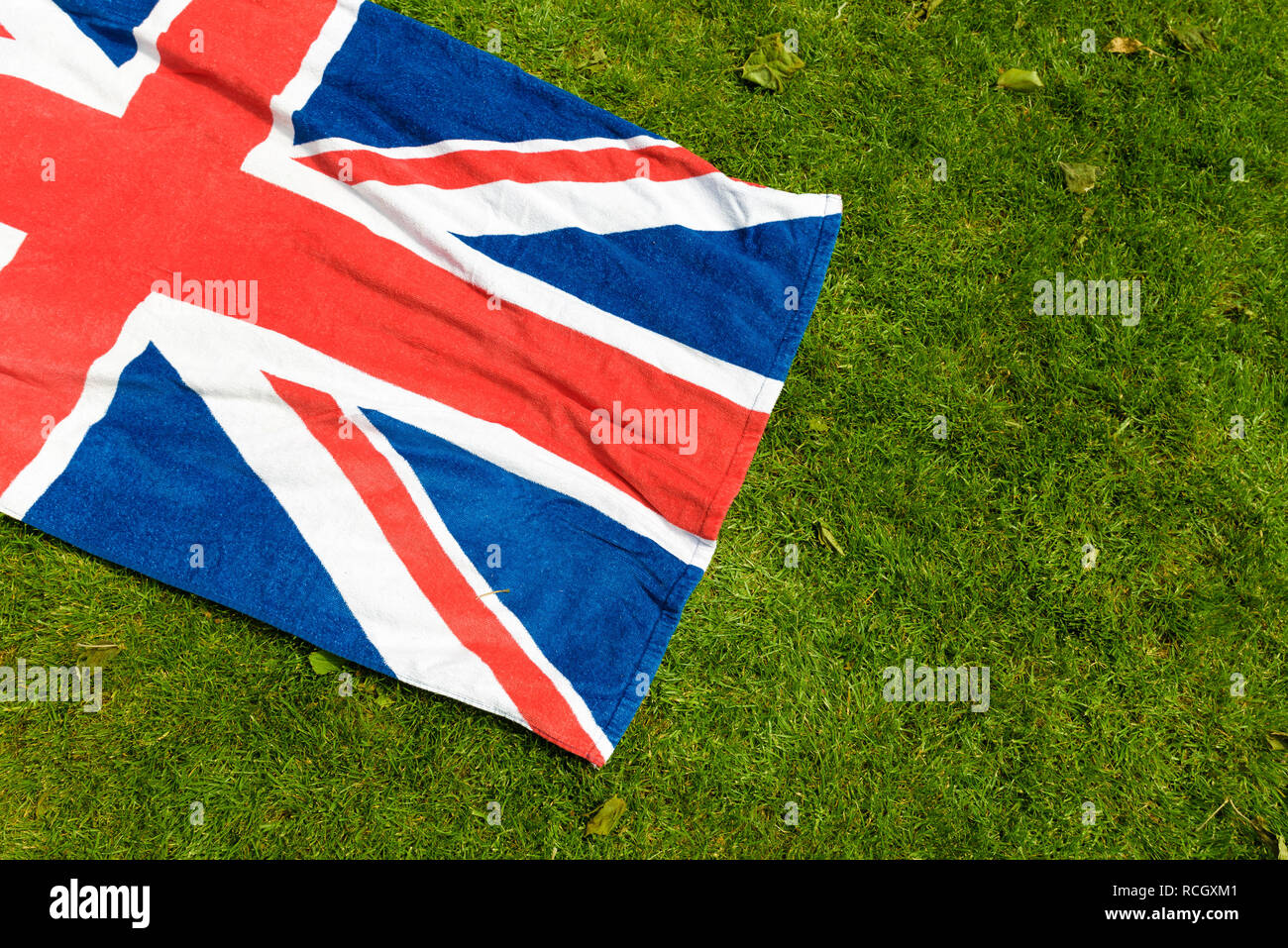 Union Jack sur l'herbe verte. Grande-bretagne et Irlande du Nord drapeau dans un parc. Serviette de plage avec le pavillon du Royaume-Uni pour un pique-nique. Banque D'Images