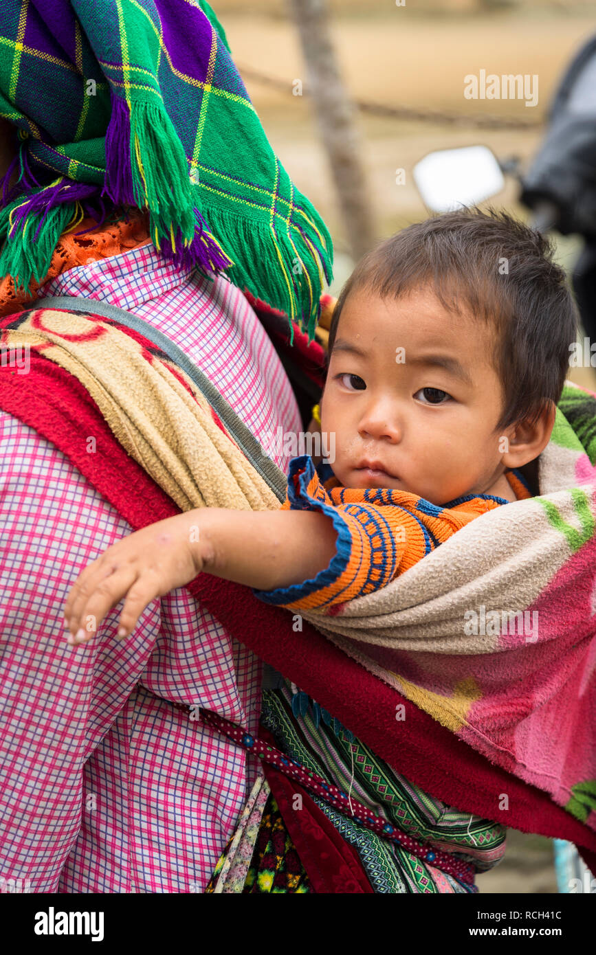 Bébé sur le dos de la mère, Bac Ha marché coloré du dimanche dans le village de la minorité Hmong fleur dans le nord du Vietnam Banque D'Images