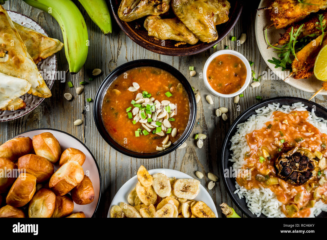 Concept alimentaire en Afrique de l'Ouest. Wset traditionnels mets africains assortiment - soupe d'arachides, de riz jollof, ailes de poulet grillées à sec, les plantains, bananes frites Banque D'Images