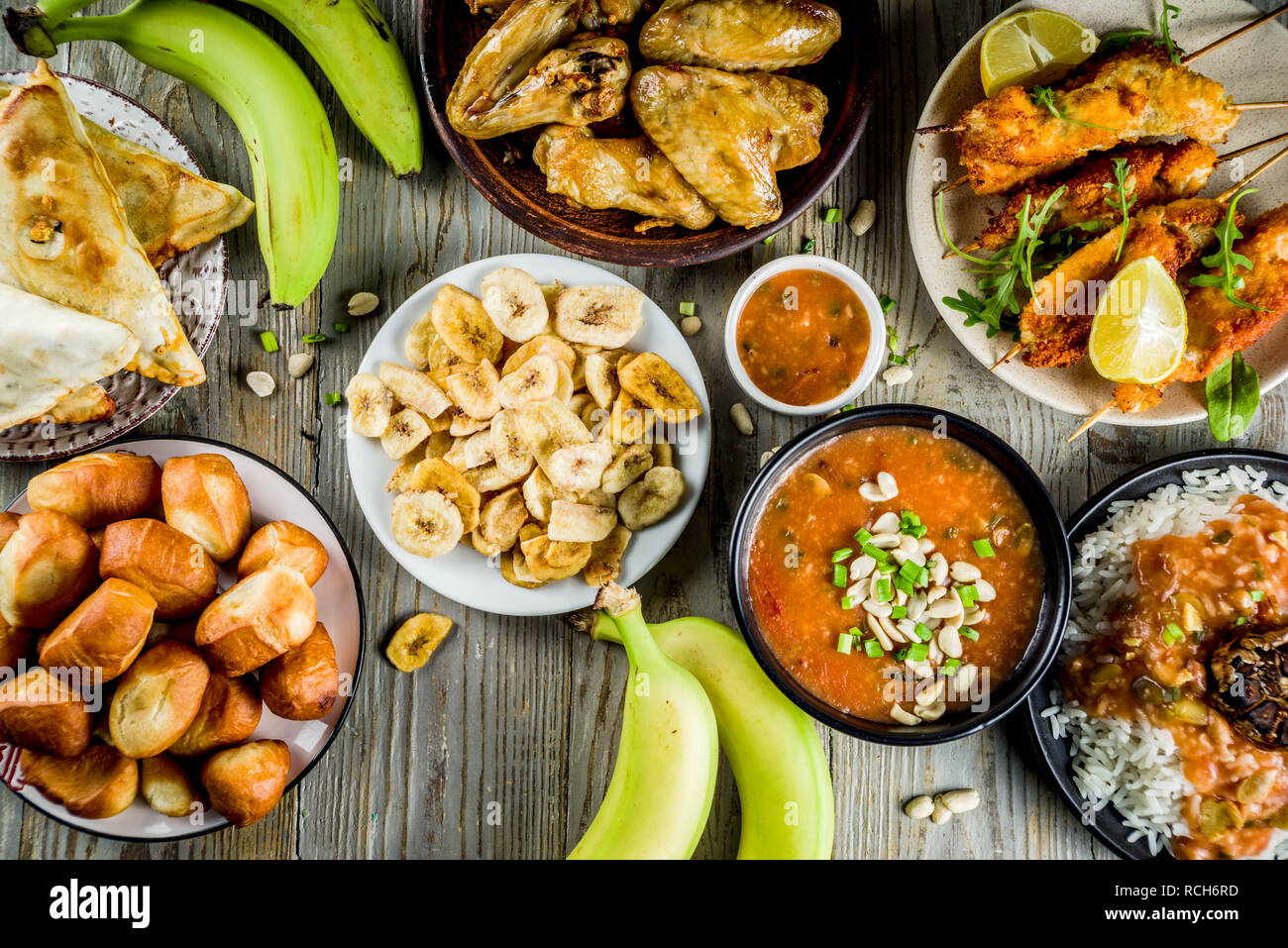 Concept alimentaire en Afrique de l'Ouest. Wset traditionnels mets africains assortiment - soupe d'arachides, de riz jollof, ailes de poulet grillées à sec, les plantains, bananes frites Banque D'Images