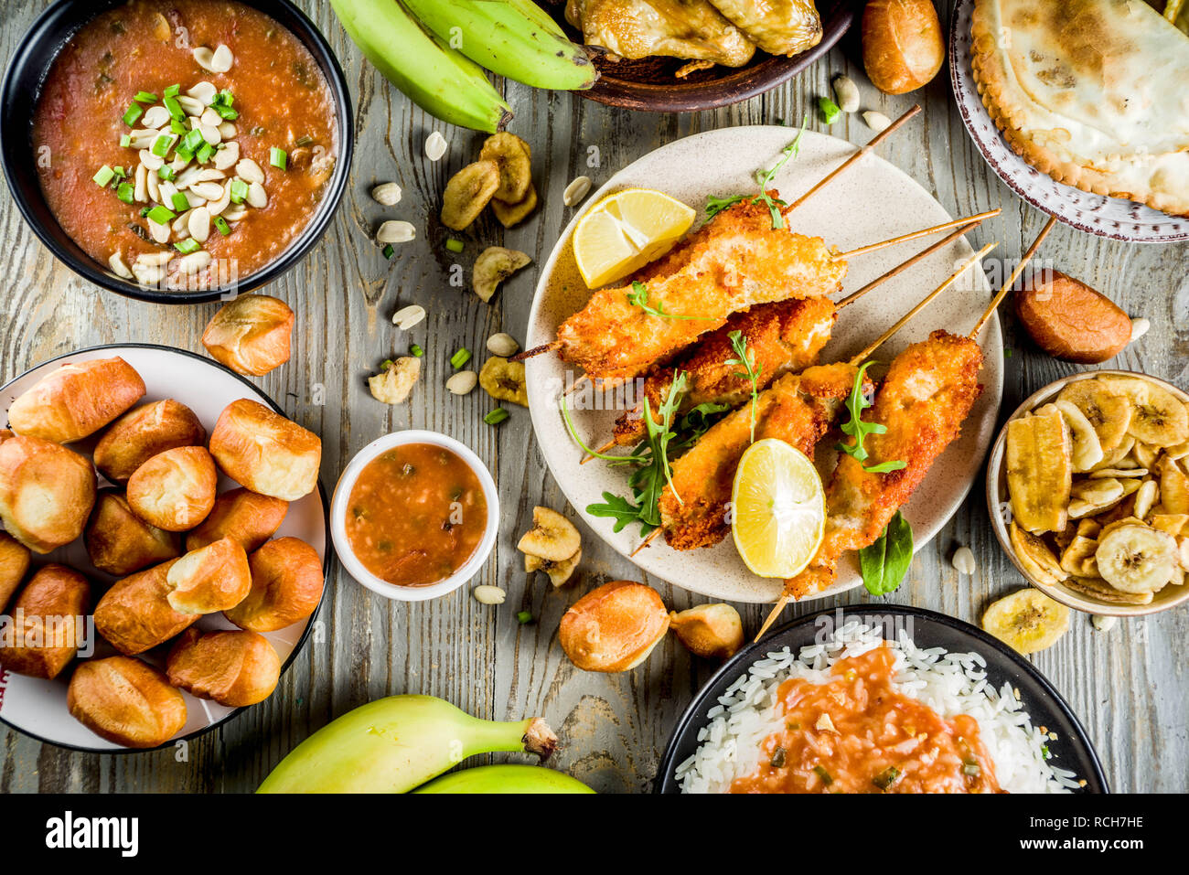 Concept alimentaire en Afrique de l'Ouest. Wset traditionnels mets africains assortiment - soupe d'arachides, de riz jollof, ailes de poulet grillées à sec, les plantains, bananes frites Banque D'Images