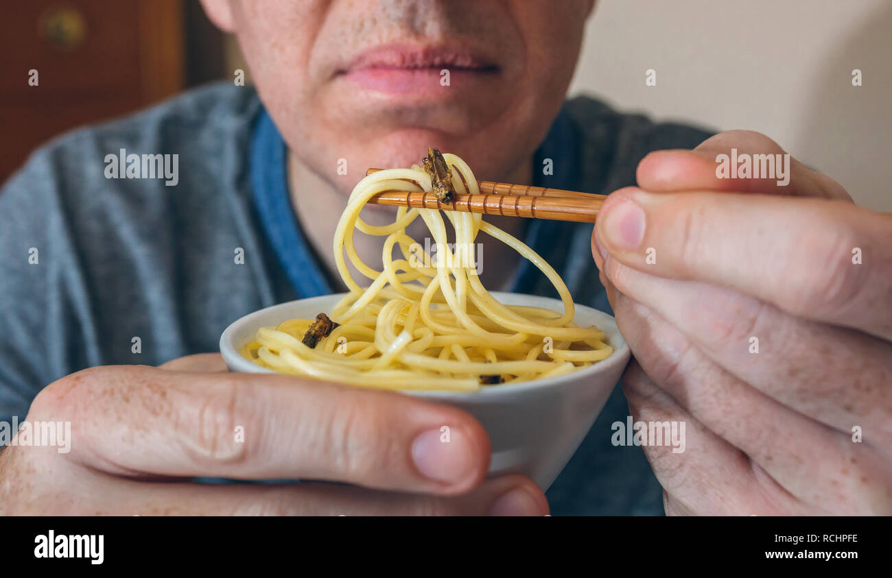 Méconnaissable man eating spaghetti aux cigales Banque D'Images