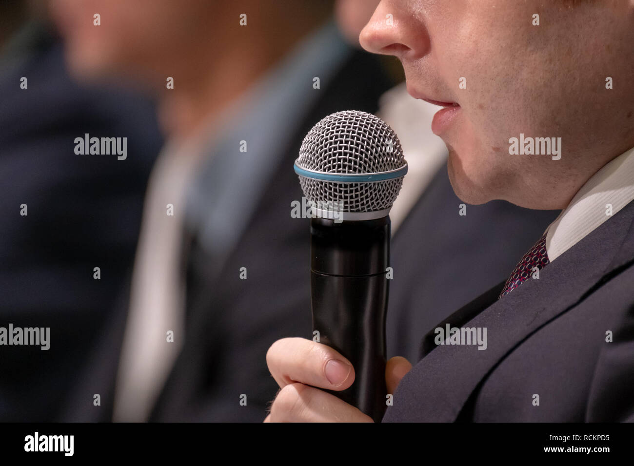 L'homme parle, tenant un microphone Photo Stock - Alamy