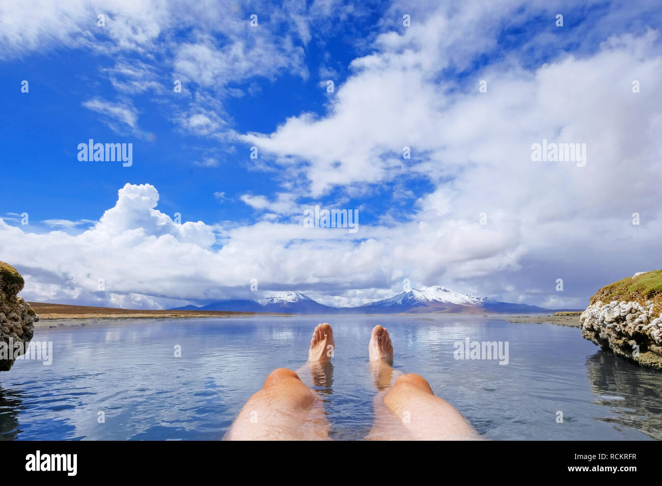 Les jambes d'un homme athlétique en thermique naturel Hot spring Polloquere Salar de Surire, salt lake, Parc National du Volcan Isluga, Chili Banque D'Images