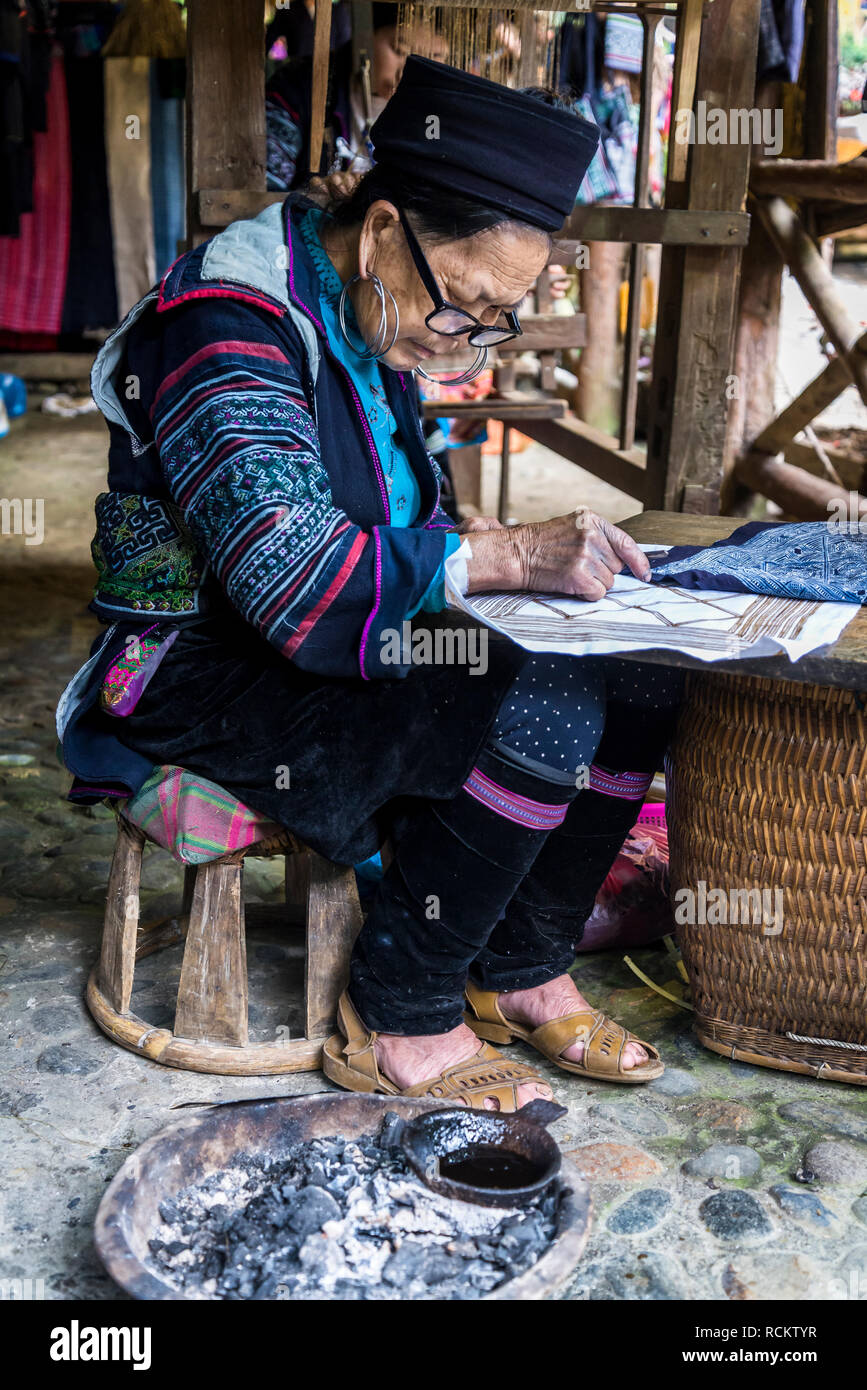 Femme faisant modèle avec la cire sur tissu, Cat Cat, un noir traditionnel village des minorités H'Mong, Sa Pa, Vietnam nord-ouest Banque D'Images