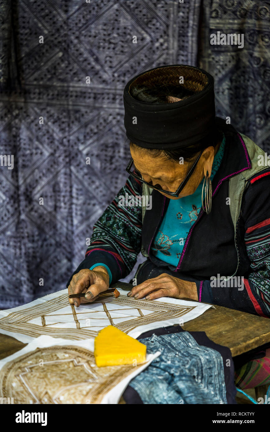 Femme faisant modèle avec la cire sur tissu, Cat Cat, un noir traditionnel village des minorités H'Mong, Sa Pa, Vietnam nord-ouest Banque D'Images