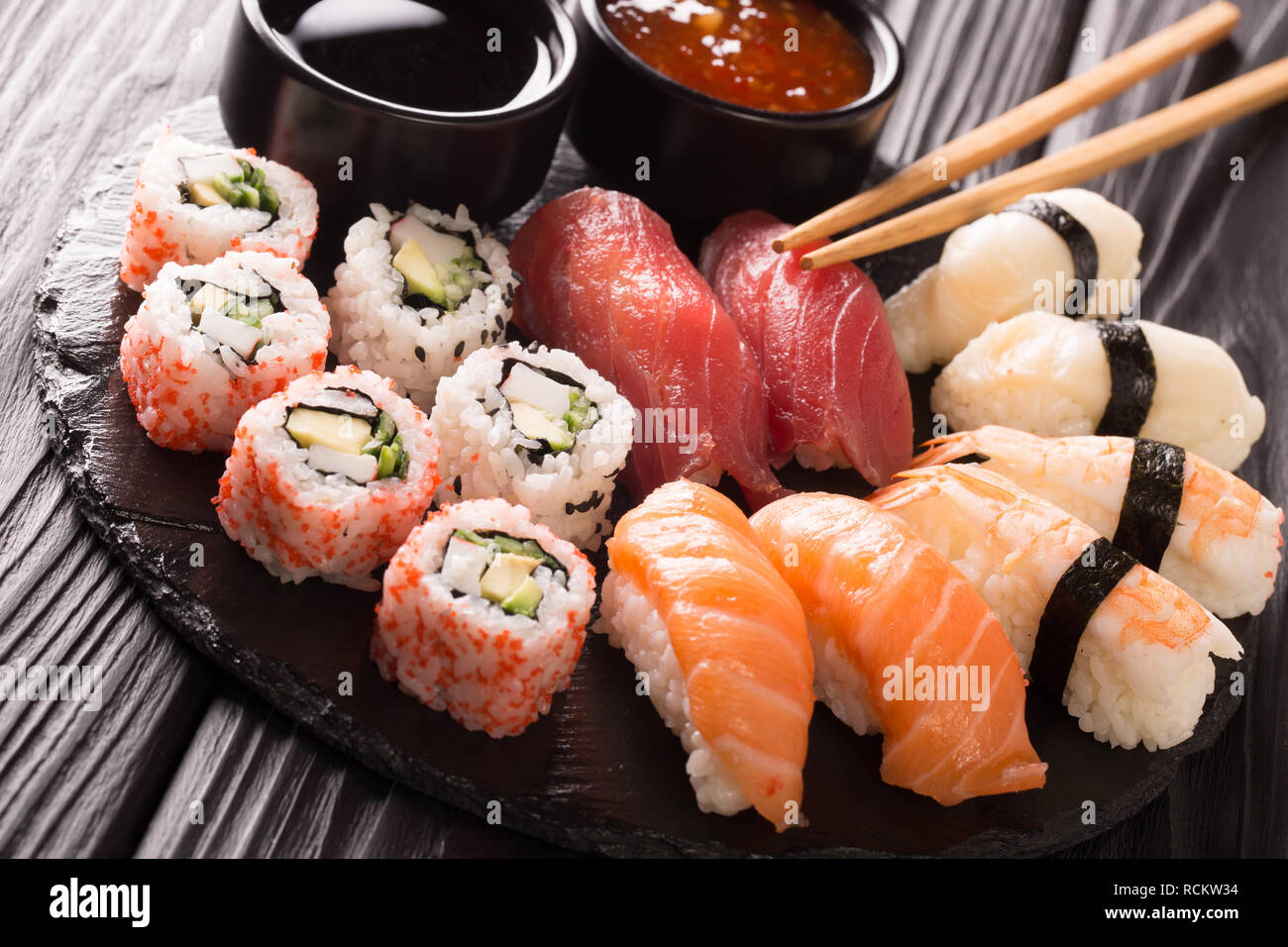 Fruits de mer restaurant traditionnel japonais, le menu photo. super haut en rouleaux de sushi frais avec le saumon, le thon, nigiri et maki servi dans la plaque noire Banque D'Images