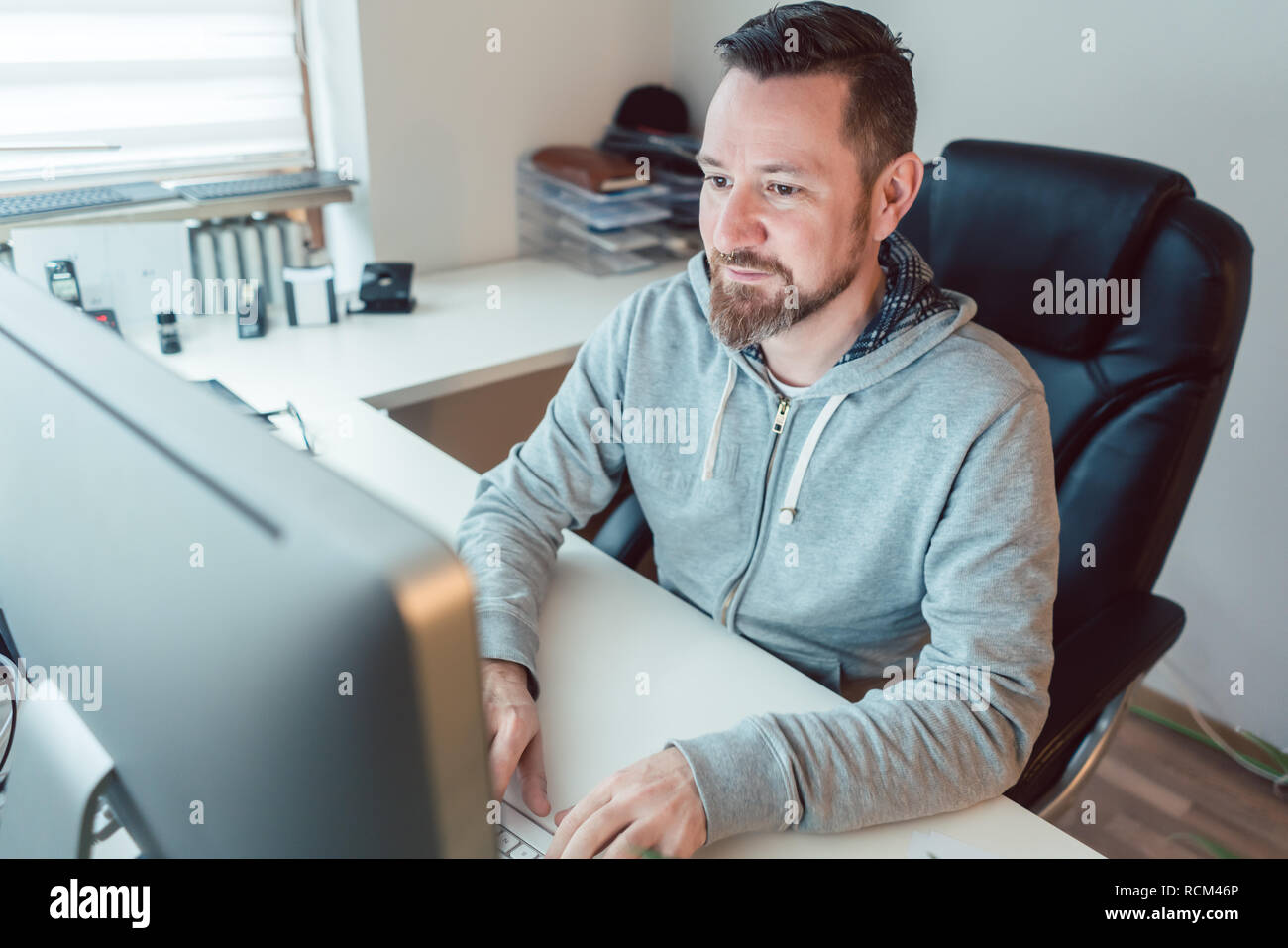 Jeune homme dans la conception de l'agence de publicité sur l'ordinateur Banque D'Images