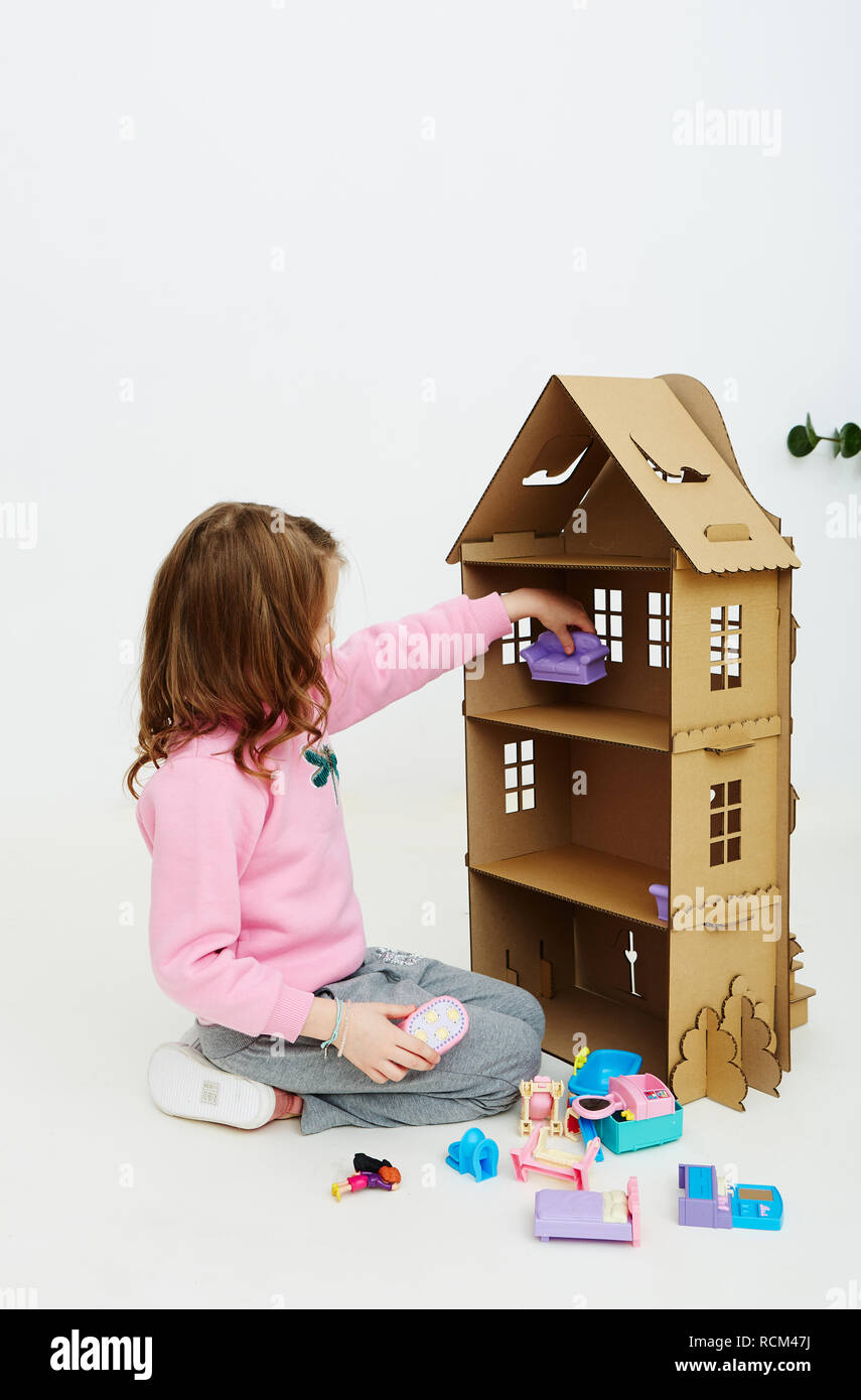 Happy girl joue avec maison de poupée en carton. Drôle belle enfant est  d'avoir du plaisir Photo Stock - Alamy