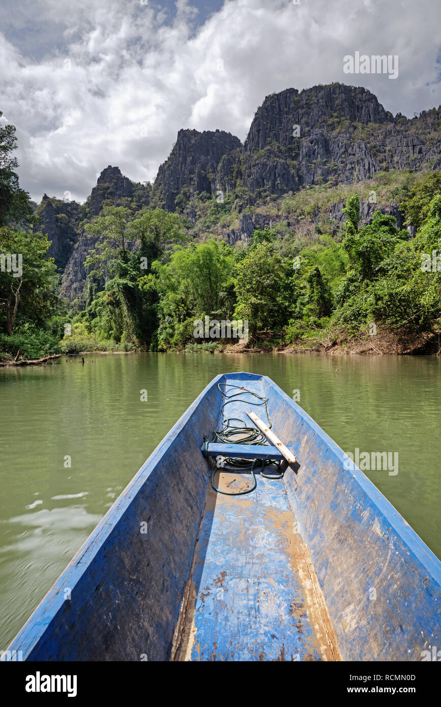 Bateau sur le Nam Hinboun River au Laos s'approchant en amont de l'entrée de la grotte de Konglor Banque D'Images