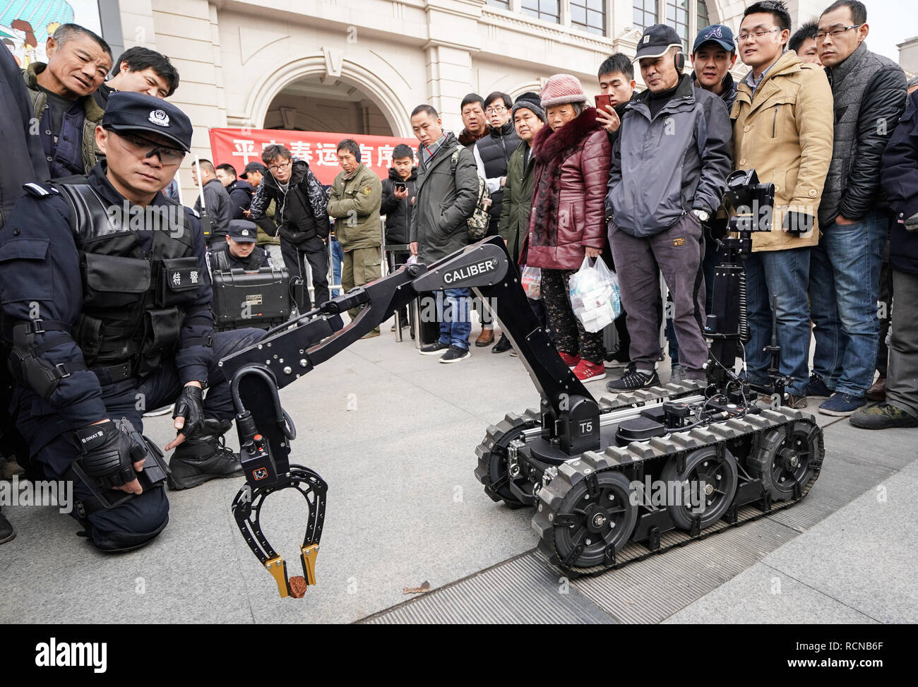 Wuhan, province du Hubei en Chine. 16 janvier, 2019. Les passagers regardez un robot de l'enlèvement des explosifs à Wuhan, province du Hubei en Chine centrale, le 16 janvier 2019. Les gares de tout le pays ont intensifié les travaux de préparation et de contrôle de sécurité pour garantir la prochaine fête du printemps pointe de trafic. Credit : Cheng Min/Xinhua/Alamy Live News Banque D'Images