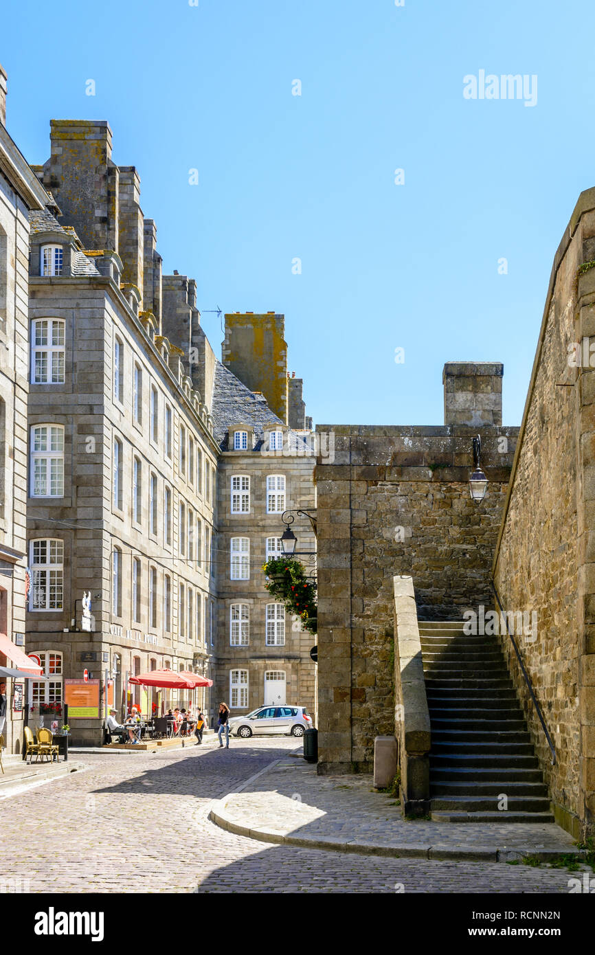 La vieille ville de Saint-Malo en Bretagne, France, avec des gens à la terrasse d'un café et un escalier menant jusqu'à la démolition de la promenade sur une journée ensoleillée. Banque D'Images La vieille ville de Saint-Malo en Bretagne, France, avec des gens à la terrasse d'un café et un escalier menant jusqu'à la démolition de la promenade sur une journée ensoleillée. Banque D'Images