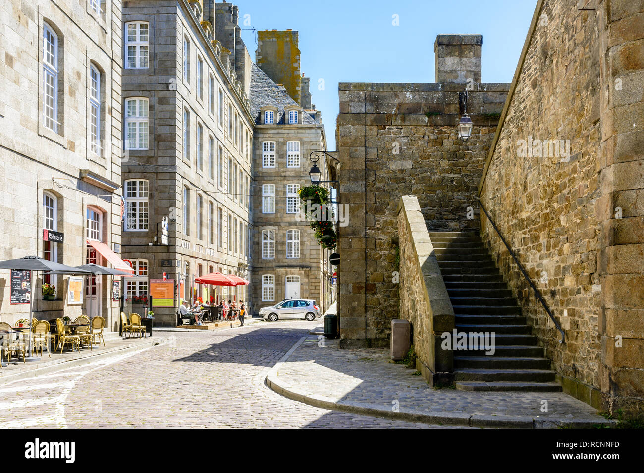 La vieille ville de Saint-Malo en Bretagne, France, avec des gens à la terrasse d'un café et un escalier menant jusqu'à la démolition de la promenade sur une journée ensoleillée. Banque D'Images La vieille ville de Saint-Malo en Bretagne, France, avec des gens à la terrasse d'un café et un escalier menant jusqu'à la démolition de la promenade sur une journée ensoleillée. Banque D'Images