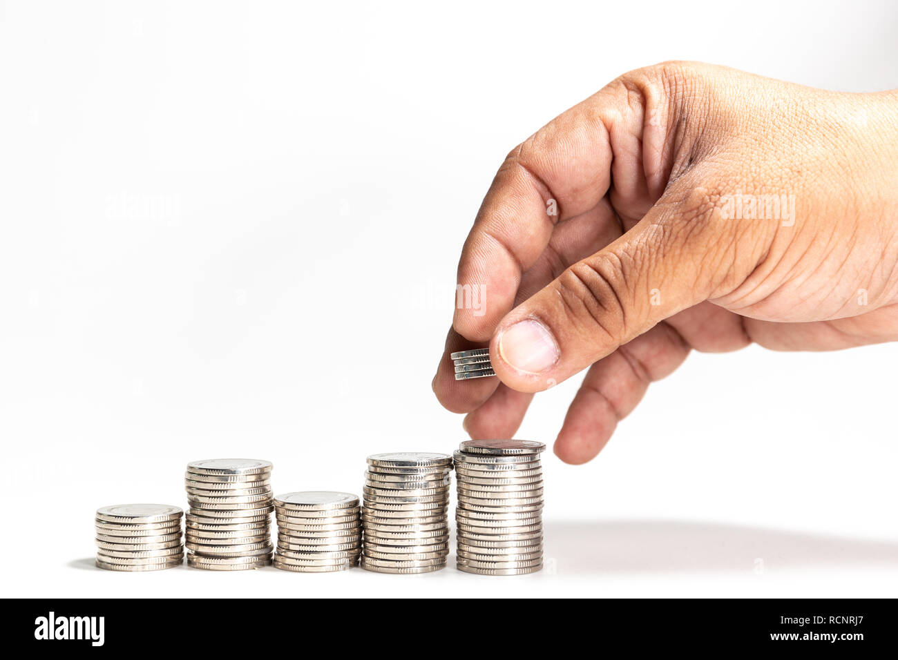 Pile de pièces d'argent avec la main sur fond blanc Banque D'Images