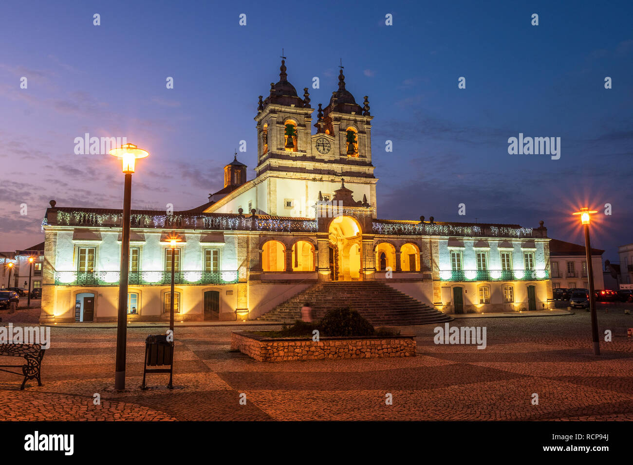 Façade principale du sanctuaire Notre Dame de Nazaré allumé et aussi avec les illuminations de Noël après le coucher du soleil. Dans le Sítio, Nazaré au Portugal. Banque D'Images