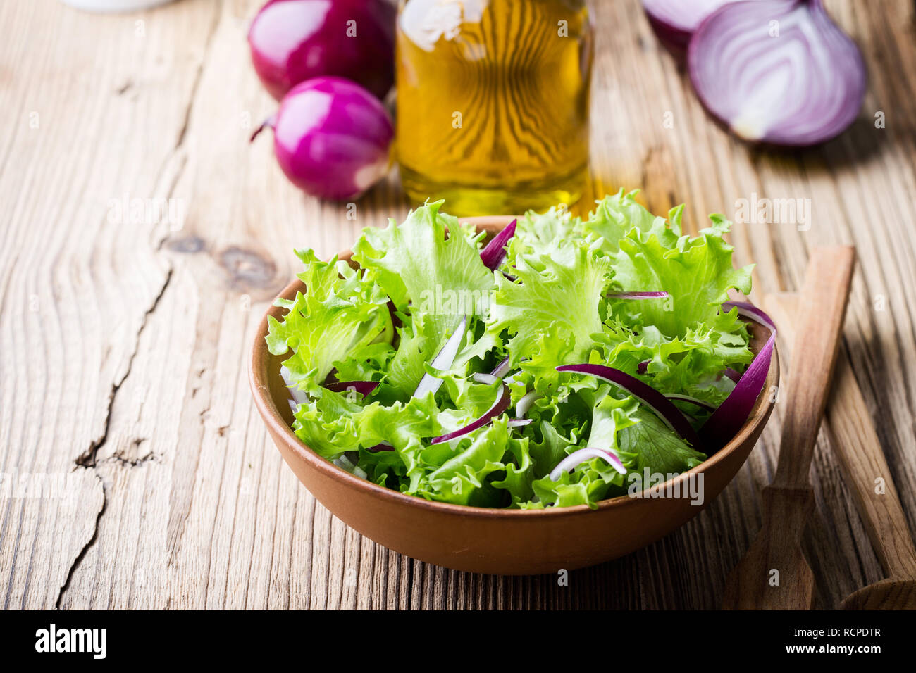 La laitue et l'oignon rouge dans un bol en céramique sur table en bois rustique, des feuilles d'une salade de légumes, repas santé à base de plantes, Close up, selective focus Banque D'Images