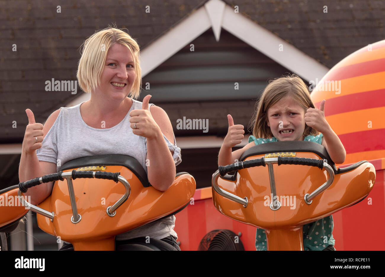 Mère et fille de 7 ans bénéficiant d'un fun ride à un plaisir au sol. Banque D'Images