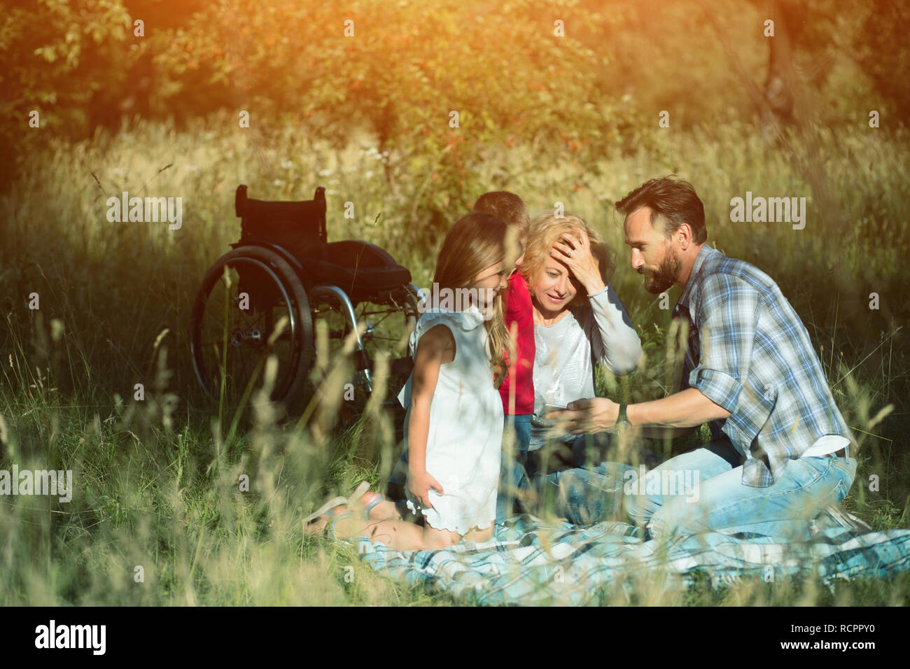 Famille heureuse de prendre le pique-nique sur selfies en parc. Paraplegic Banque D'Images