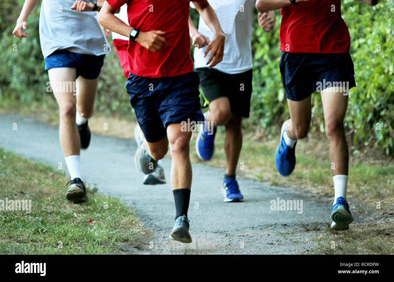Les garçons l'exécution d'un ensemble d'entraînement sur un sentier en direction du bois, Banque D'Images