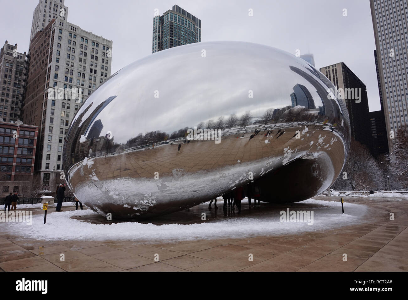 Chicago, Illinois, USA - 23/03/2015 : l'installation d'art public Bean Chicago en hiver, entouré par un anneau de la neige. Les touristes et les bâtiments show. Banque D'Images